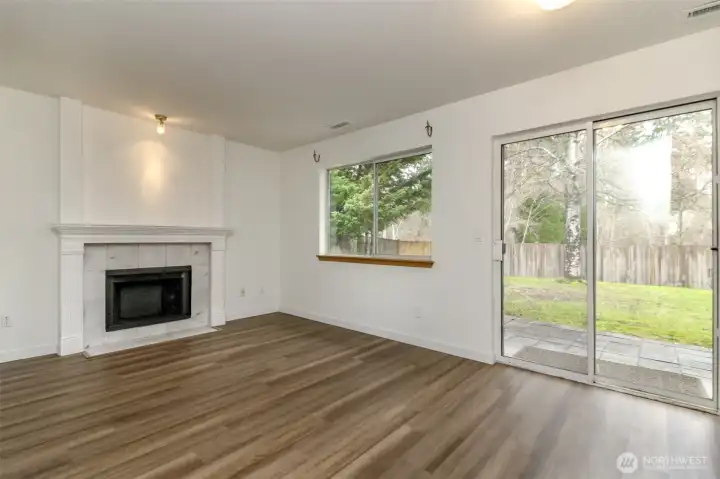 Cozy family room with wood burning fireplace. Fresh interior Paint and new LVP flooring and carpet through-out.