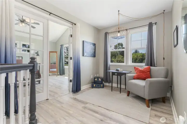 Sitting nook outside the primary suite. French doors access primary bedroom suite.