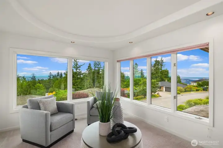 Relaxing space in the primary bedroom in front of a fireplace and with 180 degree views from Newcastle Golf Course to the Downtown Bellevue skyline and Lake Washington Relaxing space in the primary bedroom in front of a fireplace and with 180 degree views from Newcastle Golf Course to the Downtown Bellevue skyline and Lake Washington