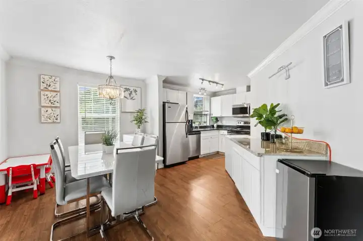 Kitchen and dining area feature an open layout with granite countertops, white cabinetry, stainless steel appliances Kitchen and dining area feature an open layout with granite countertops, white cabinetry, stainless steel appliances