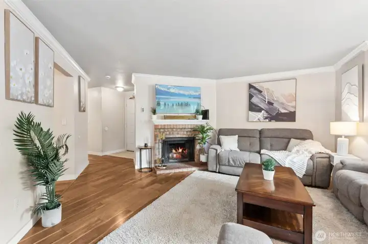 Another look at the inviting living room that offers a warm and comfortable retreat, highlighted by a cozy wood-burning brick fireplace, elegant crown molding. Also looking on to the hallways leading to bedrooms. Another look at the inviting living room that offers a warm and comfortable retreat, highlighted by a cozy wood-burning brick fireplace, elegant crown molding. Also looking on to the hallways leading to bedrooms.