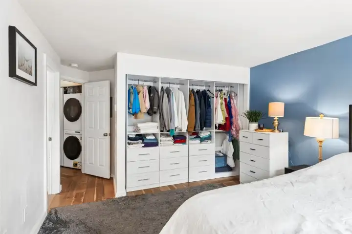 The spacious primary suite features a custom open wardrobe system with built-in drawers and shelving, providing exceptional storage and organization. A convenient in-unit laundry closet adds everyday ease, while the bright, airy layout creates a comfortable and functional retreat. The spacious primary suite features a custom open wardrobe system with built-in drawers and shelving, providing exceptional storage and organization. A convenient in-unit laundry closet adds everyday ease, while the bright, airy layout creates a comfortable and functional retreat.