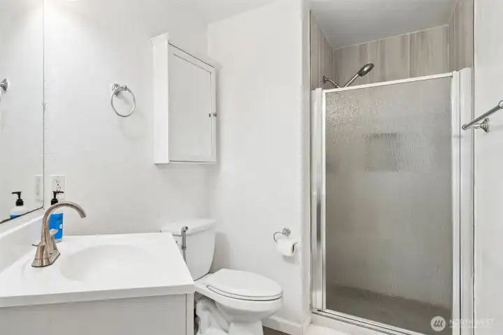 The second bathroom features a walk-in shower with glass enclosure, an updated vanity with brushed nickel fixtures, and a convenient storage cabinet. Clean, bright finishes make this bathroom both functional and inviting. The second bathroom features a walk-in shower with glass enclosure, an updated vanity with brushed nickel fixtures, and a convenient storage cabinet. Clean, bright finishes make this bathroom both functional and inviting.
