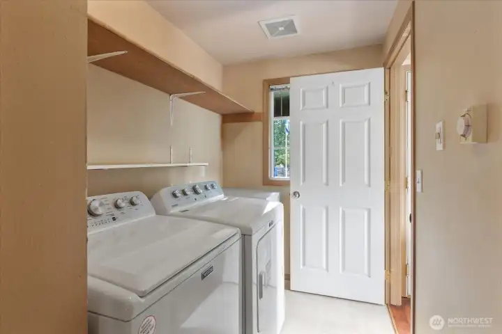Dedicated laundry room with built-in shelving and additional storage to keep everyday tasks organized.