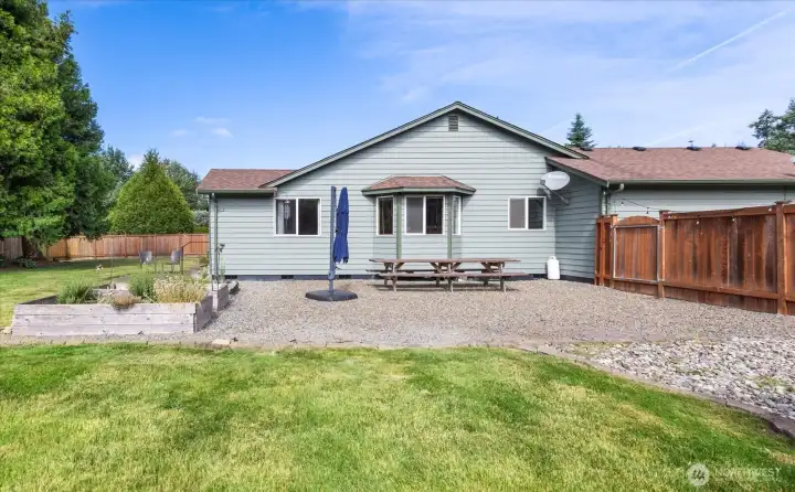 Thoughtfully landscaped with low-maintenance rock accents, mature plantings, and lush lawn, the backyard is designed for easy enjoyment.