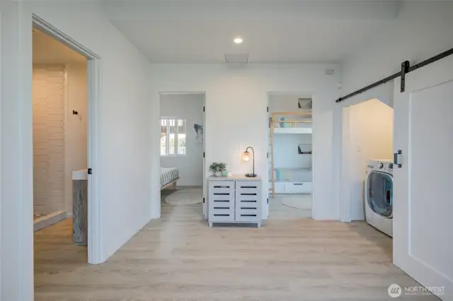 View of entry area on main level with 3/4 bath on left, 2 additional bedrooms, and utility closet on the right.
