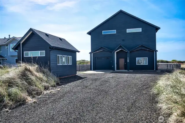 View of home, driveway and detached building w/heat & power. Could be a home office, gym or craft space.