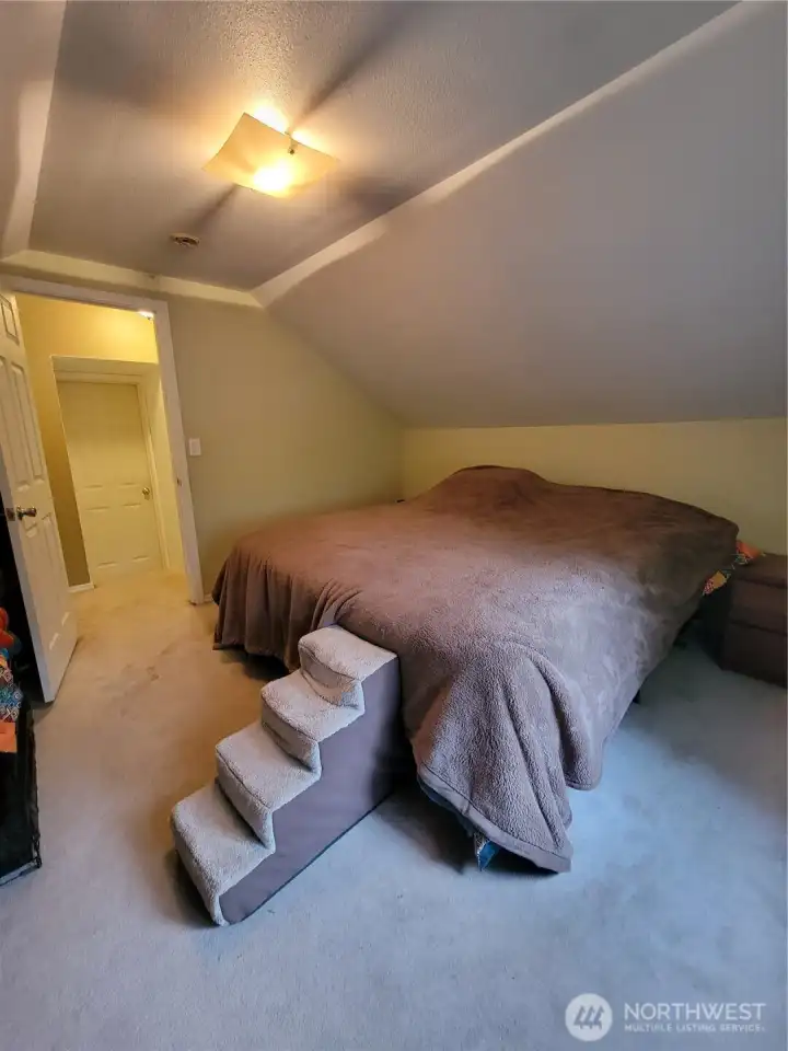 Bedroom #3, on the upper level, looking back at the landing of the staircase. Door to bedroom #2 is visible.