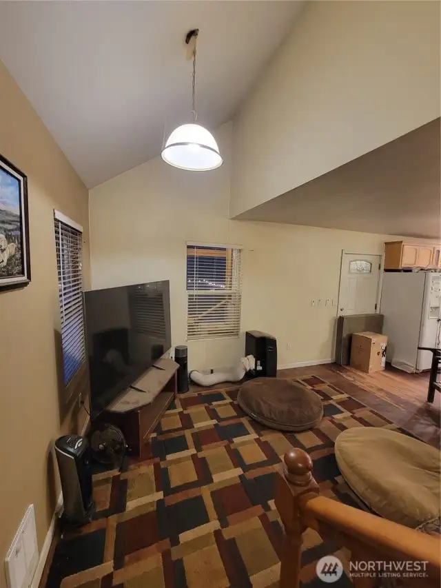 From the staircase back into the living room with partial vaulted ceiling.