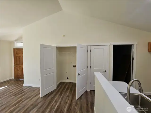Family room looking at laundry room, front door pantry closet and garage entry