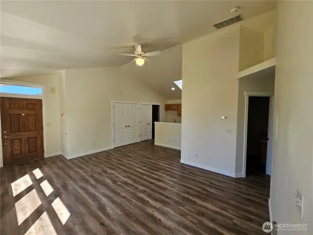 Family room with LVP, ceiling fan and vaulted ceiling