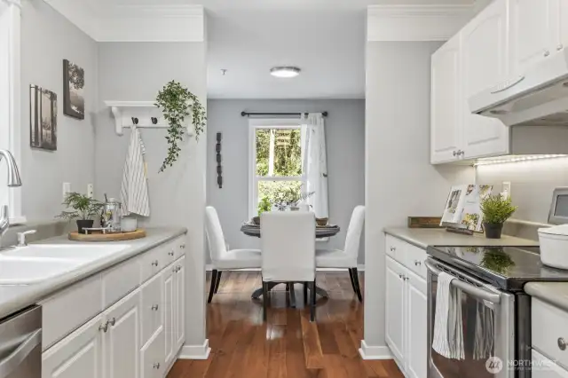 The kitchen boasts crisp white cabinets, offering plenty of storage, along with abundant counter space.