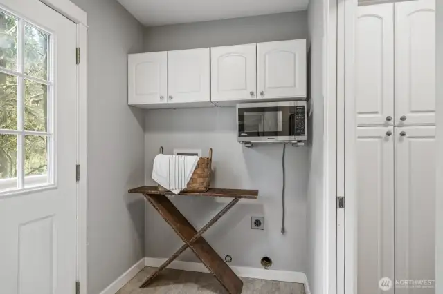 The functional laundry/mudroom features convenient access to the backyard.