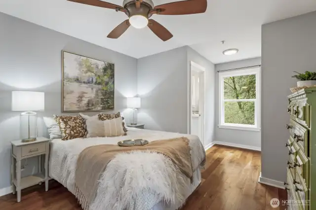 The primary bedroom offers a peaceful retreat, featuring an entrance to the private bath, a bright window for natural light, a spacious closet, and a ceiling fan for added comfort.