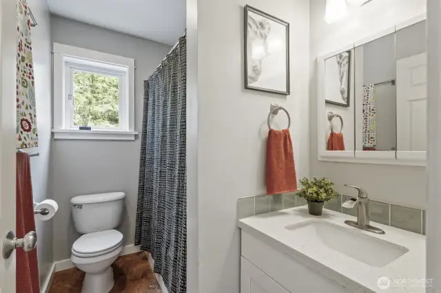 The updated full guest bath features modern fixtures and beautiful cork flooring.