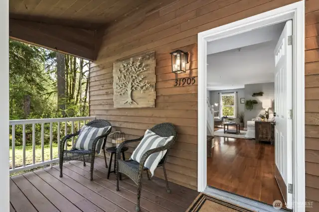 Charming covered porch entrance welcomes you with warm wood accents —an inviting first impression that sets the tone for this peaceful country retreat.