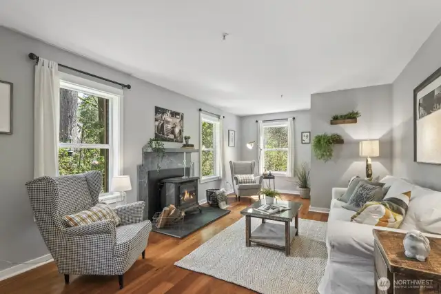 The main living area is beautifully light-filled, with large windows that bring the outdoors in and create a warm, airy ambiance throughout the space.