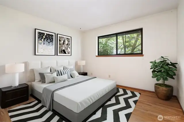 Main level bedroom with views toward the front of the home. Original hardwood floors. Virtually staged to show potential of this space!
