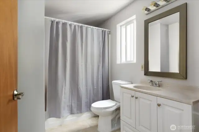 Full bathroom with storage room behind door. *Tenant's furnishings have been digitally removed.*