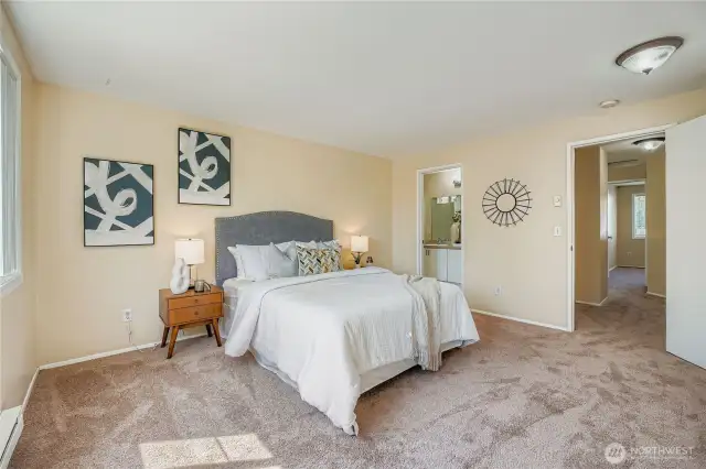 Spacious primary bedroom featuring a brand-new light fixture and plush carpeting. Enjoy the convenience of an attached en-suite bath, creating a private retreat within the home.