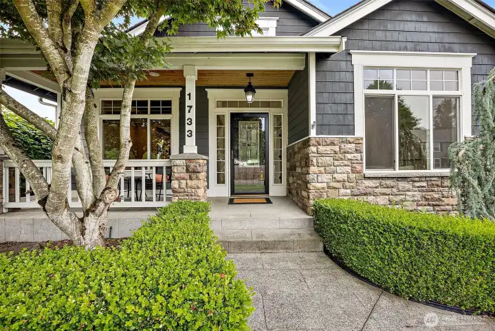 Front porch entry way lined with manicured landscaping and craftsman curb appeal.