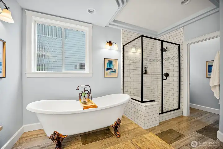 Primary en-suite bath with clawfoot soaking tub and subway tiled shower