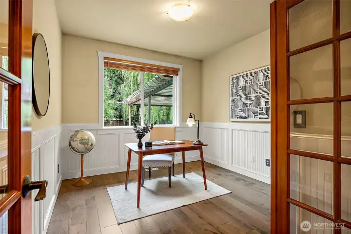 Main floor office/den space with French doors and window looking out to backyard patio