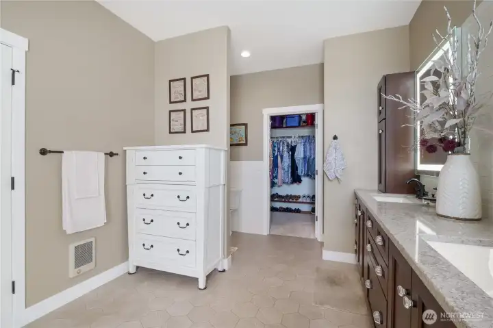 Elegant primary bath with granite double vanity and tile shower.