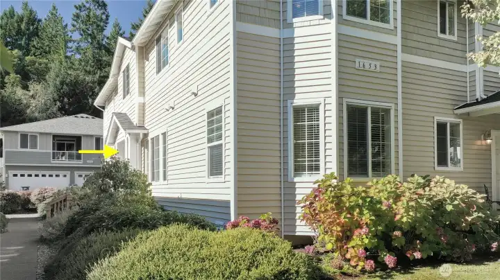 Side entry into home with five steps up to a covered porch area.