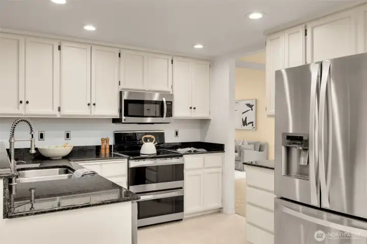 Recently refreshed kitchen is bright with granite counters & SS appliances