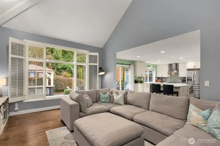 Oversized windows framed by plantation shutters overlooking the garden.