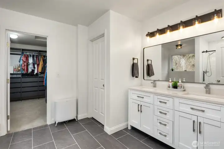 Updated primary bath with organized walk-in closet and double vanity.