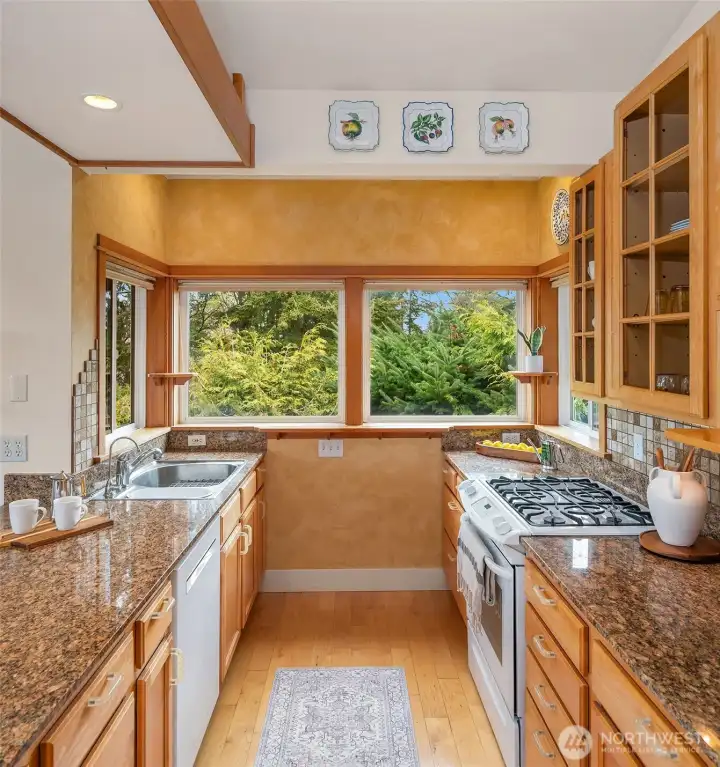 Efficient galley kitchen with plenty of storage, counter space and natural gas stove.
