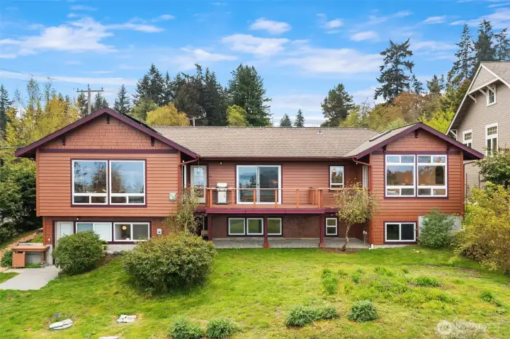 North elevation. Great room is on the left in this photo, primary bedroom is in the middle and second bedroom with atrium is on the right. Lower level shop on left, bedroom in middle and basement storage on right.