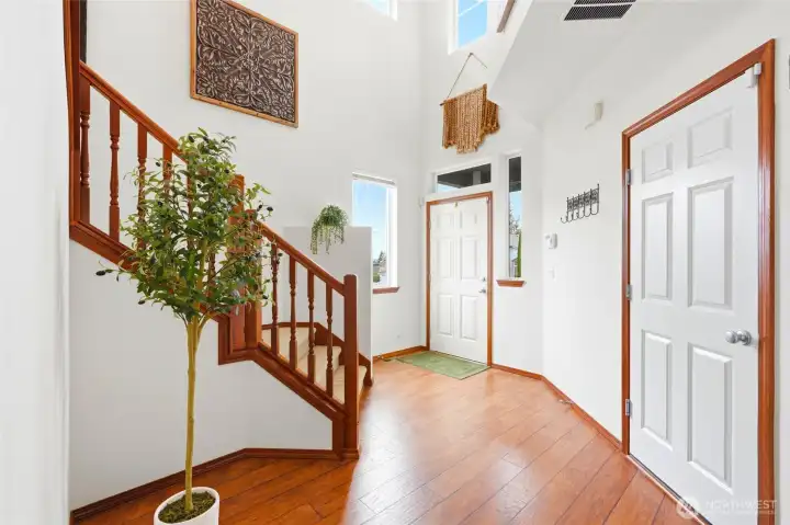 Vaulted entry and rich hardwood floors welcome guests as they arrive.