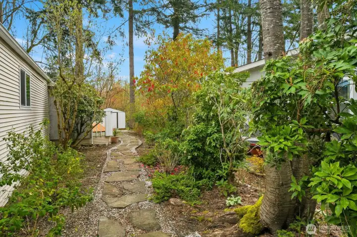 This lovely garden path with pavers leads to the back of the home. Enjoy the greenery, nature sounds and the open greenbelt space behind the home.