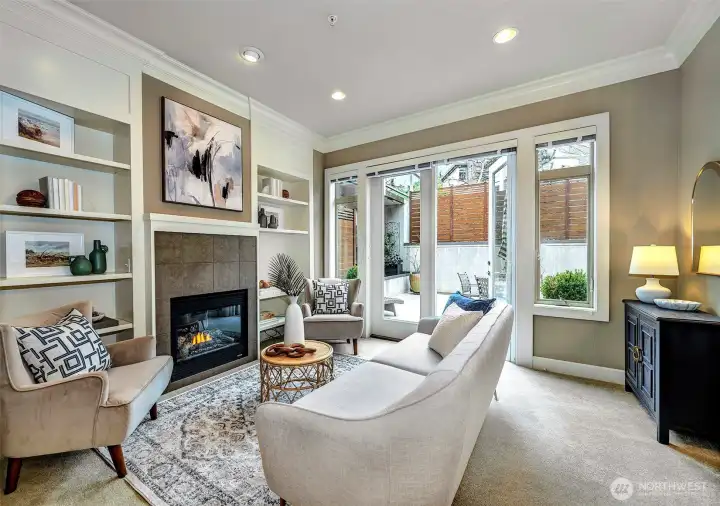 Living room with cozy gas fireplace, built in shelving and French door to large patio oasis.