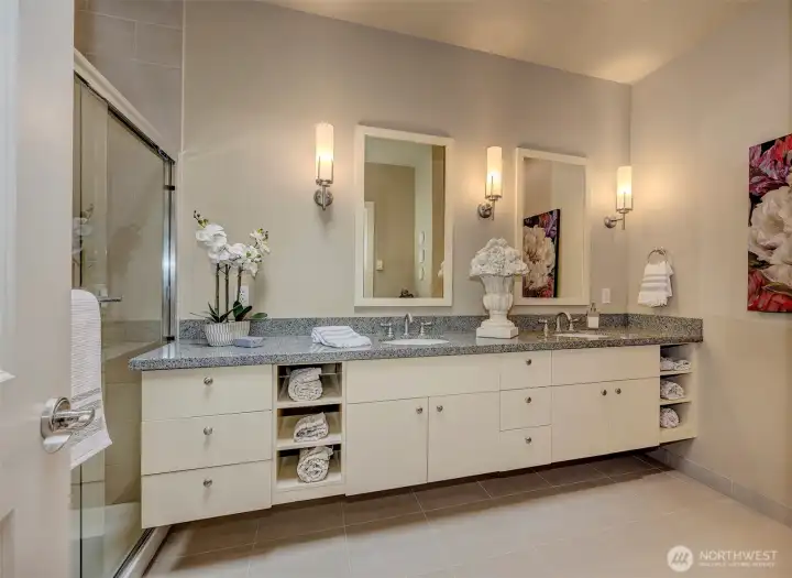 Primary bath with double vanity, walk in shower and linen closet.