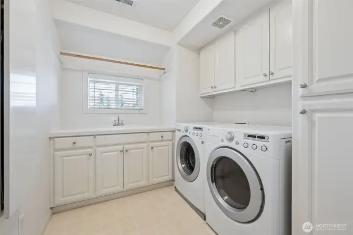 large utility room with utility sink and storage