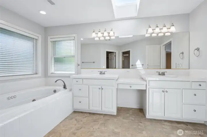 5 piece primary bathroom including water closet with stand-uo shower and a soaker tub.