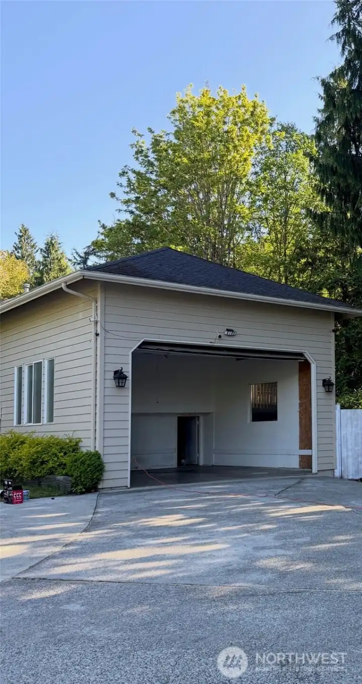 Oversized attached two-car garage with high ceilings, potential boat/ RV parking inside and outside garage