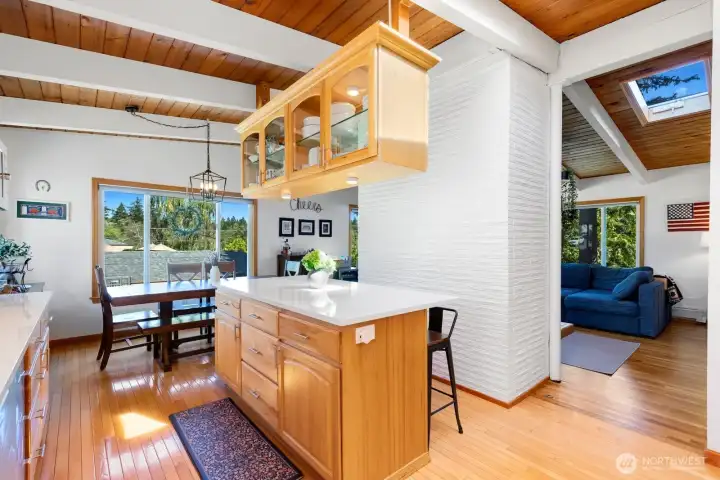 In the kitchen, with the dining and living rooms beyond, and the brick fireplace chimney center stage. In the kitchen, with the dining and living rooms beyond, and the brick fireplace chimney center stage.