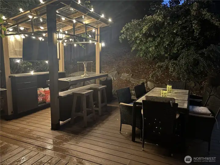 Evening view of the outdoor bar/kitchen, with plenty of cafe lights to warm up your party. Evening view of the outdoor bar/kitchen, with plenty of cafe lights to warm up your party.