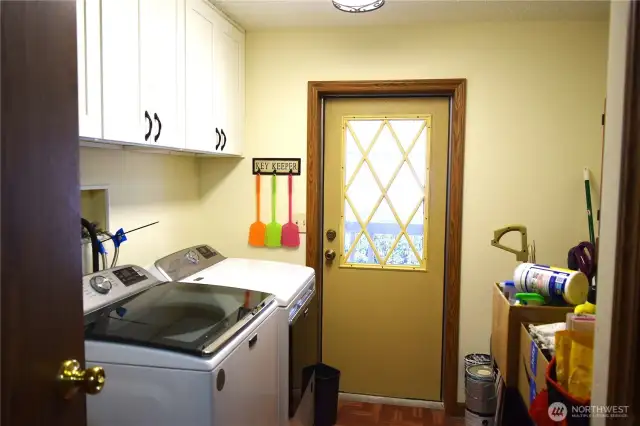 Mud room entrance with new washer/dryer that stay with the home