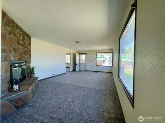 Living room with lots of light and a wood burning fireplace.
