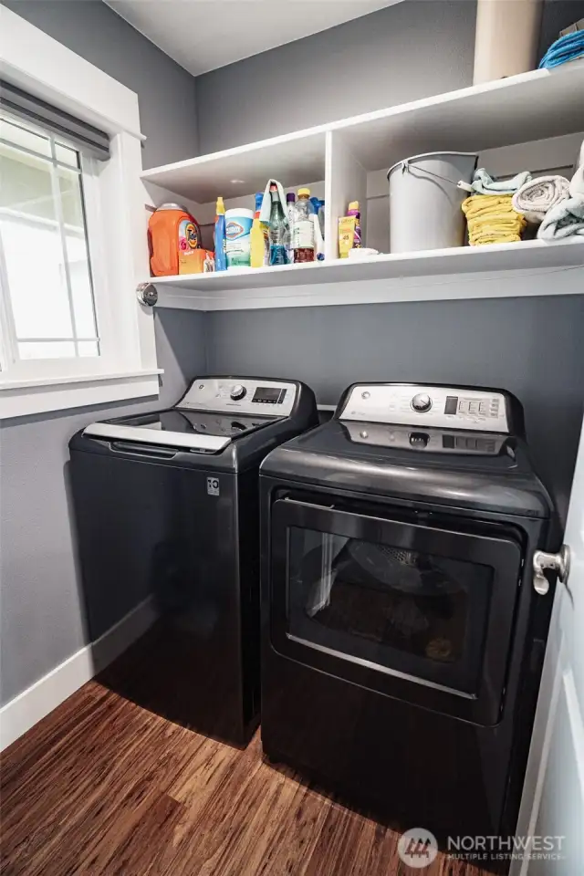 Laundry room with plenty of storage above and a window to let in natural light.