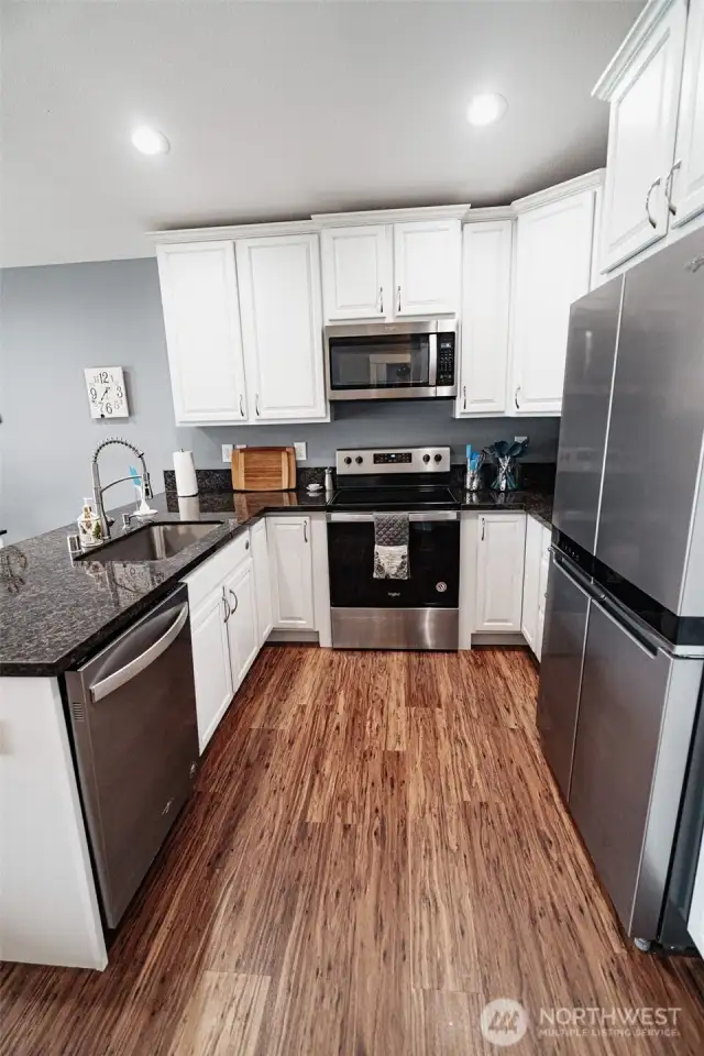 Stainless steel appliances and stone countertops.