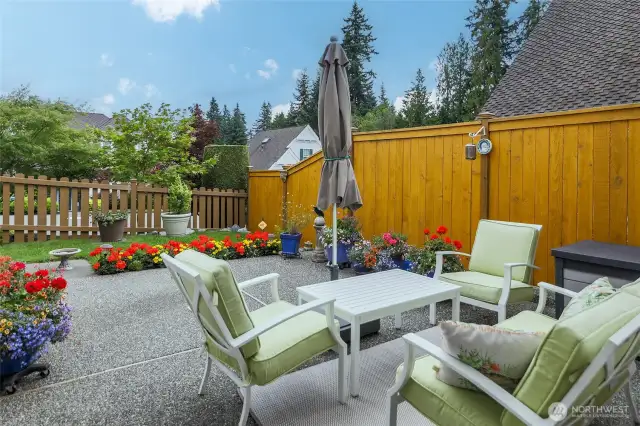 Fenced patio area off kitchen, your choices for garden color, planters, outdoor furniture with umbrella (fence freshly painted), sweet bird bath, storage.