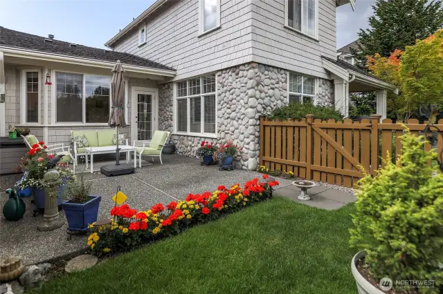 View from patio to external kitchen, living room, entry area, fence.