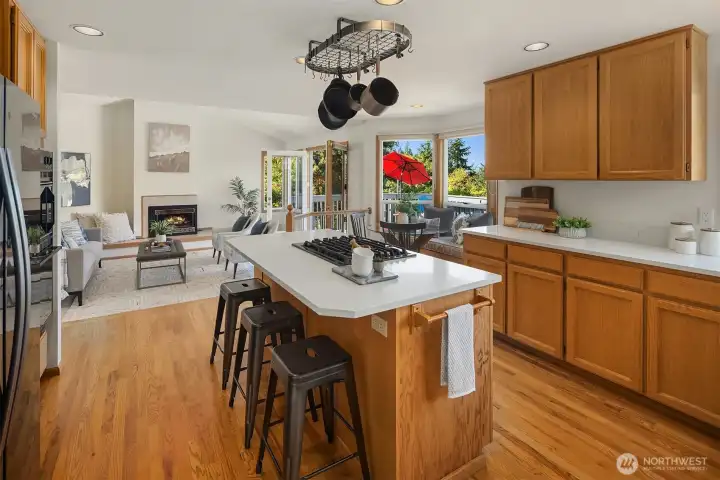 The island Kitchen features newer quartz counters with a large undermount double sink and hot/cold filtered water dispenser